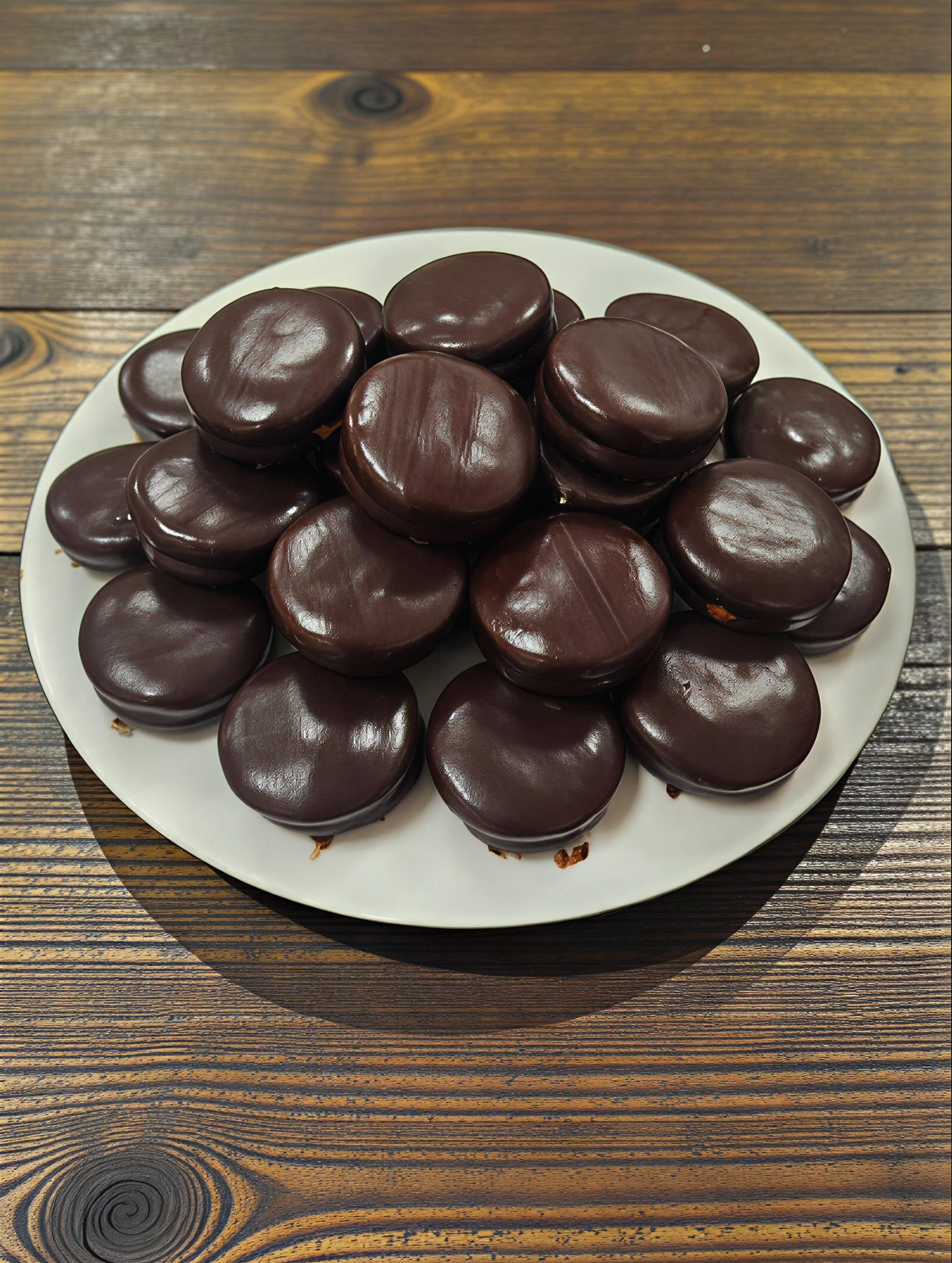 Csokoládés sütemények tányéron, faasztalon.