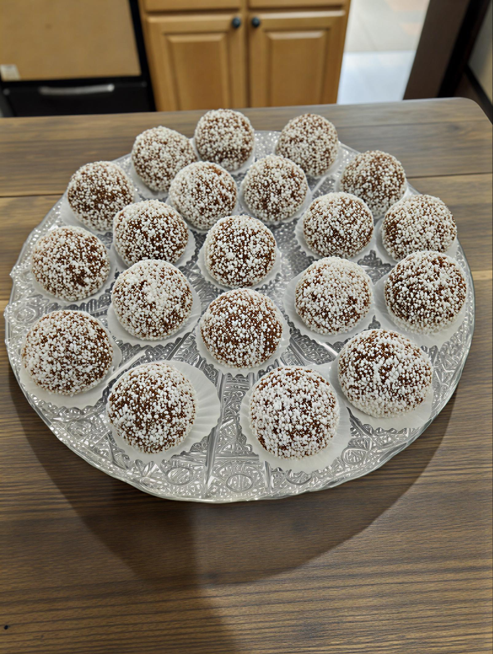 Csokoládé süteménygolyók kókuszreszelékkel díszítve tálcán.